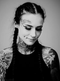 Close-up of young woman against gray background