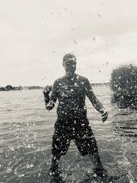 Full length of man standing on sea shore against sky