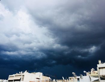 Low angle view of buildings against cloudy sky