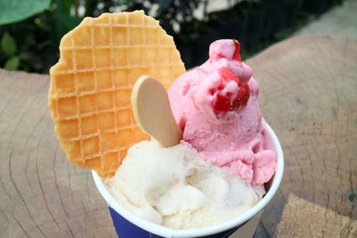 Pink and white gelato with waffle in cup photo