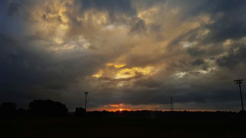 Silhouette of trees against dramatic sky during sunset