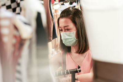 Woman wearing mask in clothing store