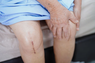 Midsection of couple hands on bed