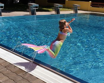 Full length of girl diving in swimming pool