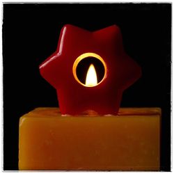 Close-up of illuminated candle against black background