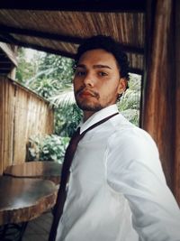 Portrait of young man standing at home