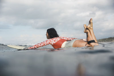 Female surfer lying on surfboard