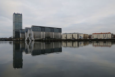 Buildings in city against cloudy sky