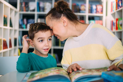 Mom and her little child, the preschooler son, read together children's books