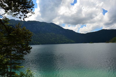 Scenic view of lake by mountains against sky