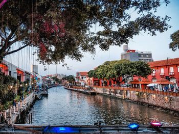 Canal amidst buildings in city against sky