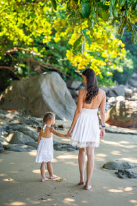 Side view of young woman standing at beach