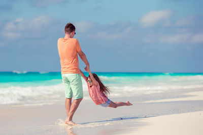 Full length of child on beach against sky