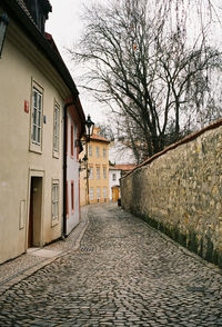 Retaining wall by footpath against houses