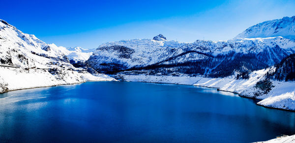 Scenic view of snowcapped mountains against blue sky