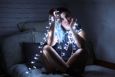 Young woman posing with christmas lights