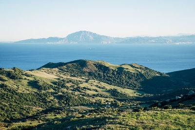 Scenic view of sea and mountains against sky