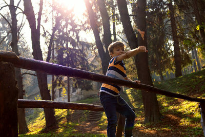 Man standing by railing in forest