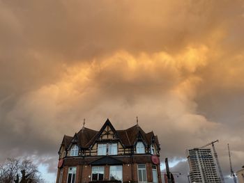 Low angle view of buildings against cloudy sky