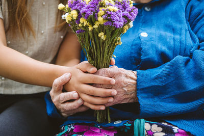 Grandparents day, reunited family, togetherness. senior old grandma hugs granddaughter outdoors