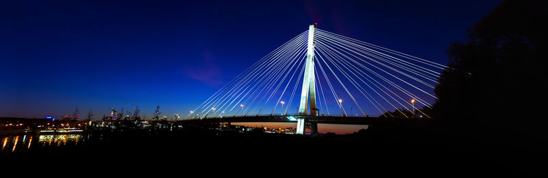 Illuminated city against clear sky at night