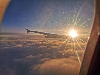 Airplane flying in sky at sunset