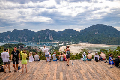 People on shore against sky