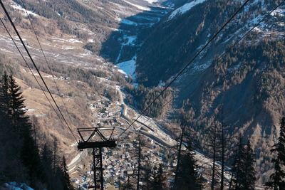 Overhead cable car on landscape against sky