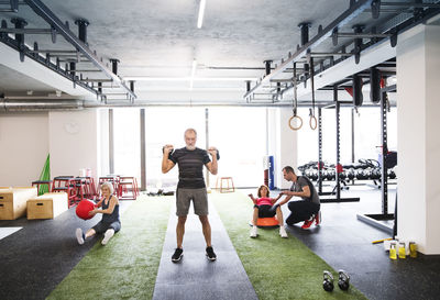 Group of fit seniors with personal trainer in gym