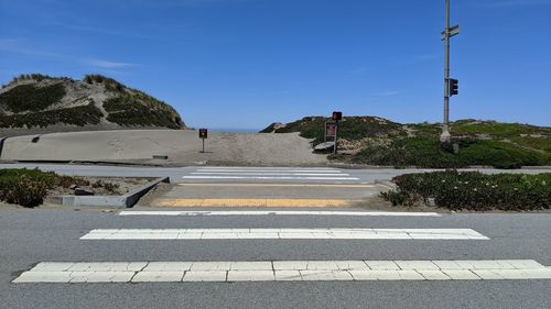 Empty road by street against sky