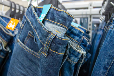 Close-up of jeans hanging in store for sale