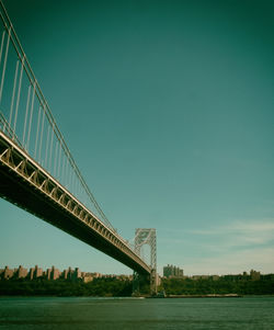 Low angle view of george washington bridge over hudson river against sky