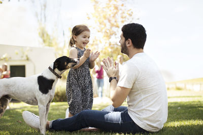 Happy father, daughter and dog in garden