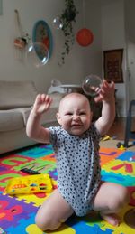 Cute boy playing with balloons at home