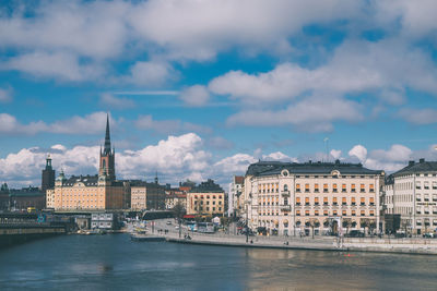 View of buildings in city against cloudy sky