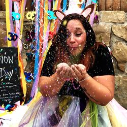 Woman blowing confetti at party