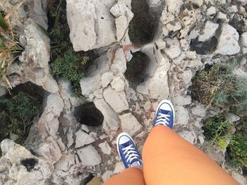 Low section of woman standing on rock