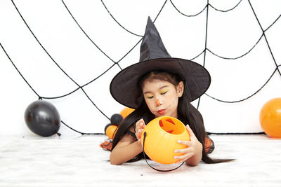 Full length of cute boy with pumpkins in park during halloween