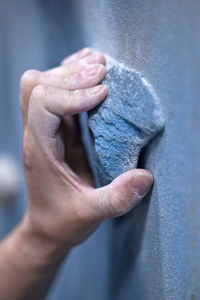 Close up of hand holding on to handhold at indoor climbing gym