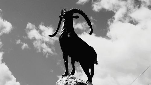 Low angle view of horse statue against sky