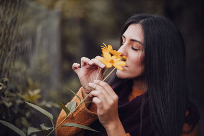 Close-up of woman smelling flower