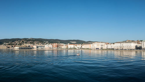 Sailboats in sea against clear blue sky