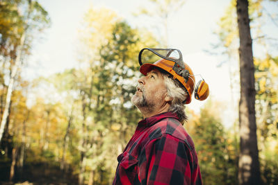 Side view of lumberjack looking away in forest