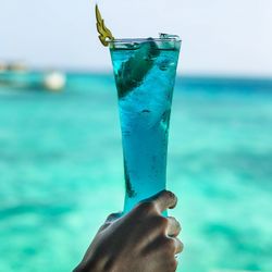 Close-up of hand holding glass of water