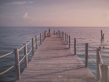 Jetty over sea against sky during sunset