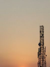 Low angle view of communications tower against sky during sunset