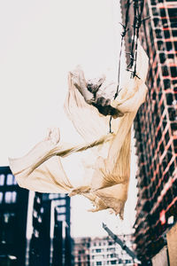 Low angle view of flying plastic bag against sky