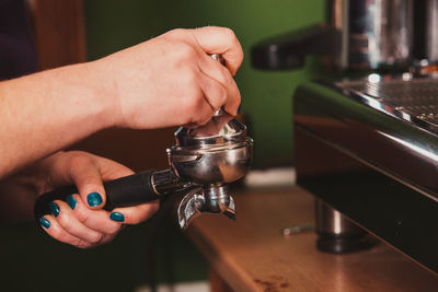 Midsection of barista preparing coffee