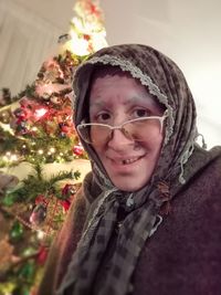 Portrait of smiling woman with christmas tree in snow
