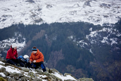 Couple resting on the way up helvellyn mountain in the lake district